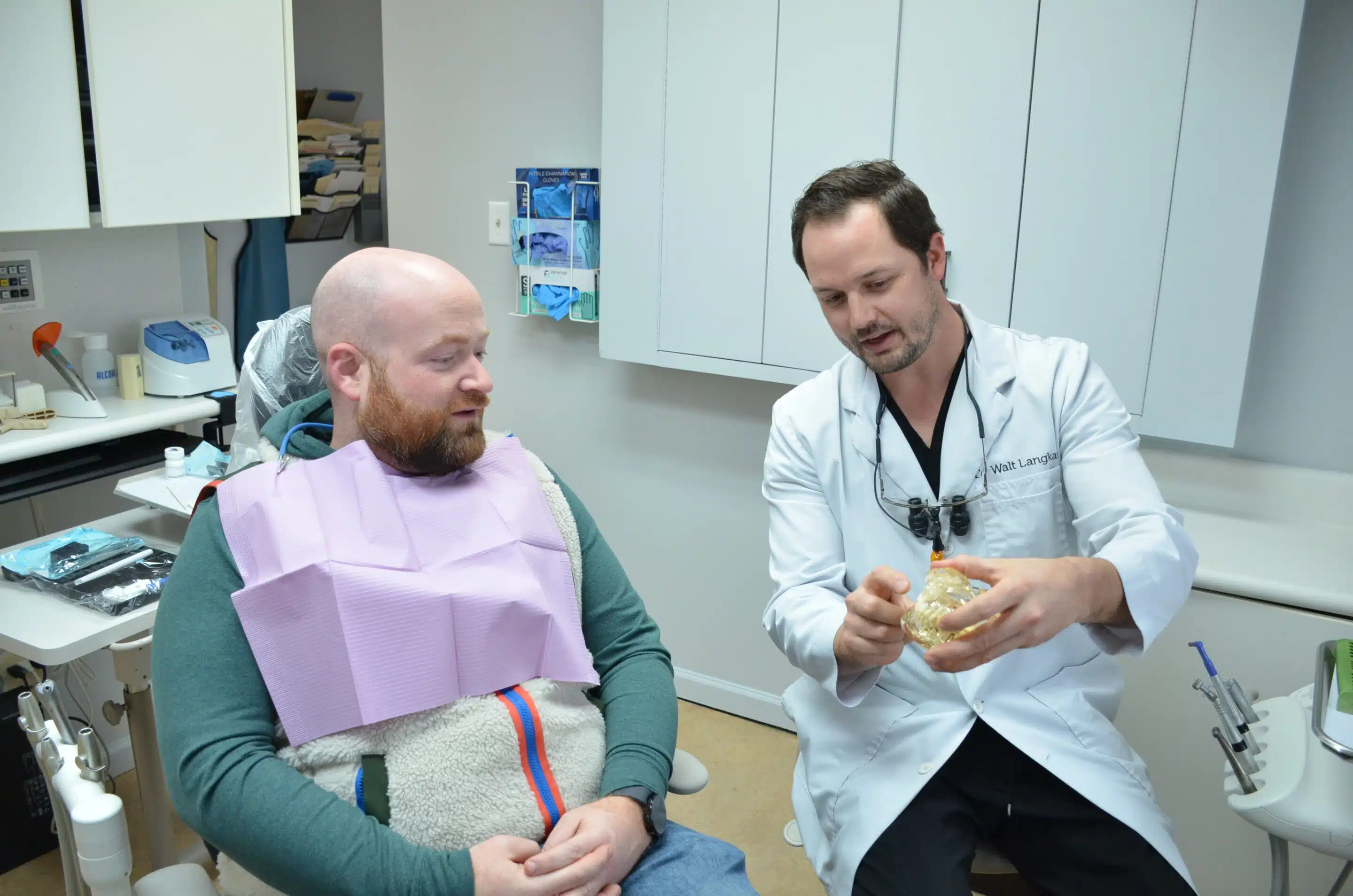 Dentist sitting next to a patient waiting in the dental chair