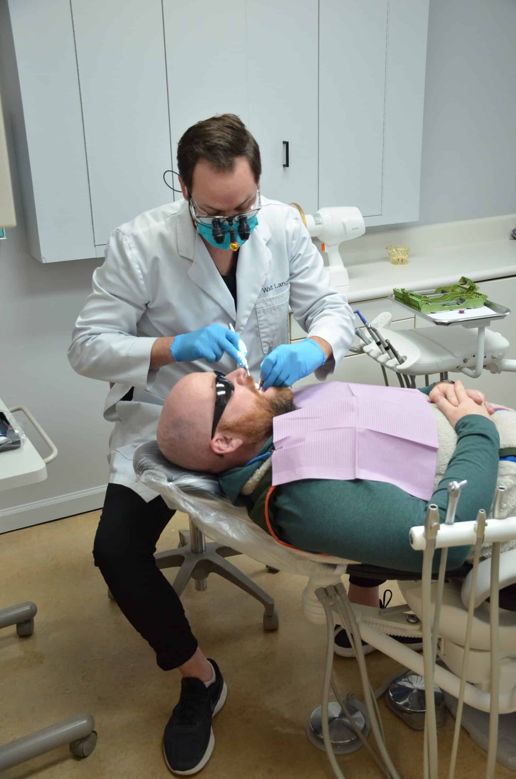 Male doctor showing x-ray pictures of teeth on tablet